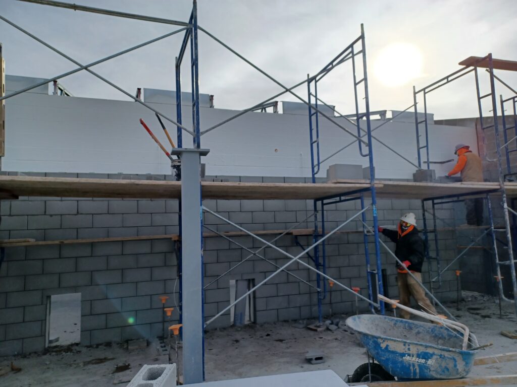 exterior white brick wall with scaffolding