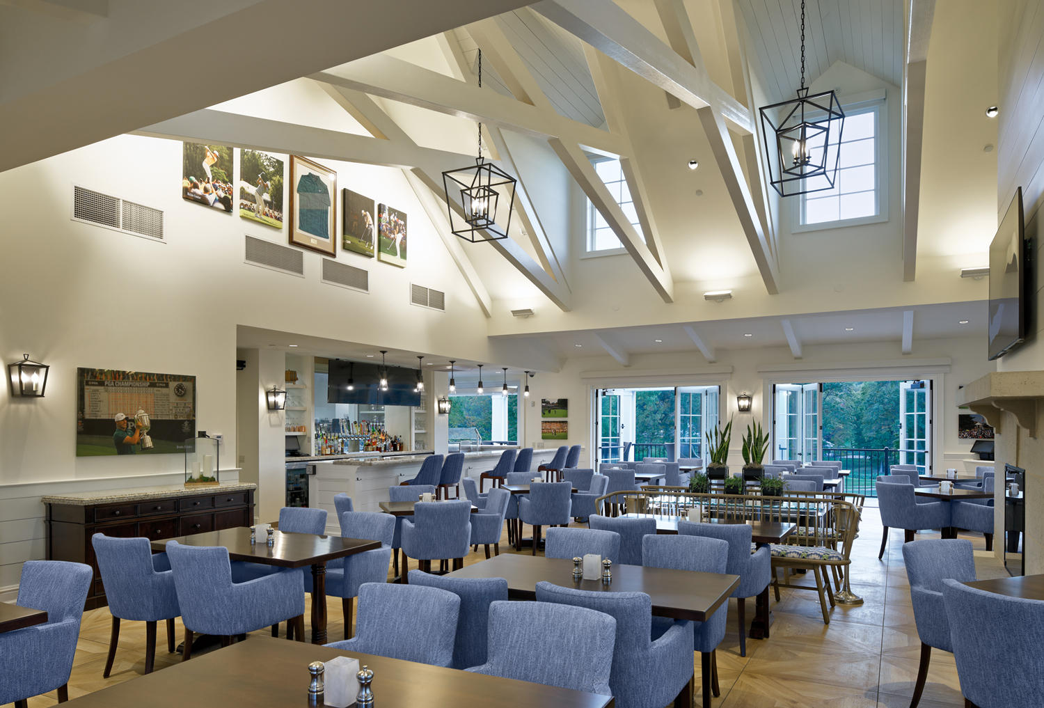 Interior view of dining room with blue chair and vaulted ceiling.
