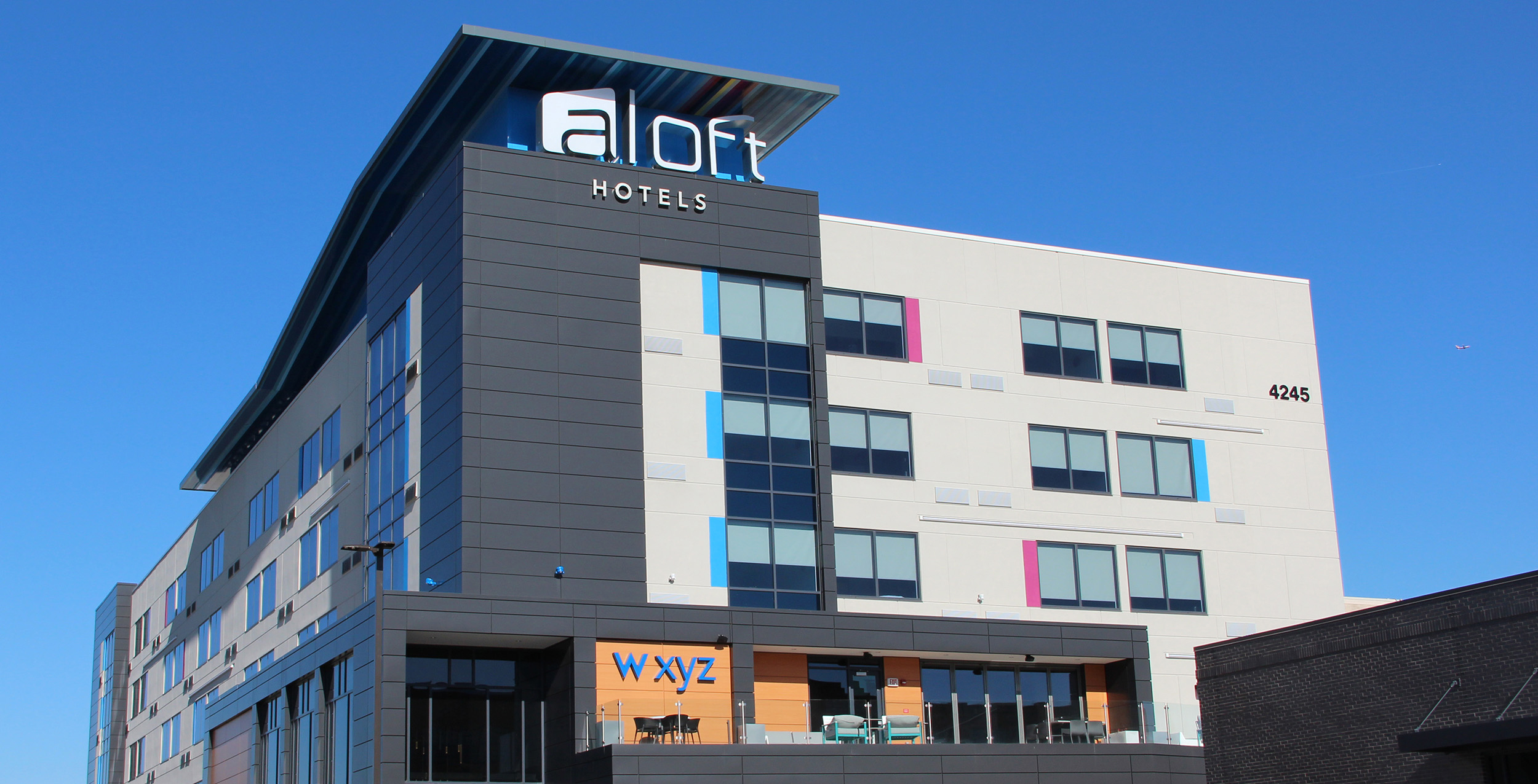 5 story grey hotel building in the Cortex District