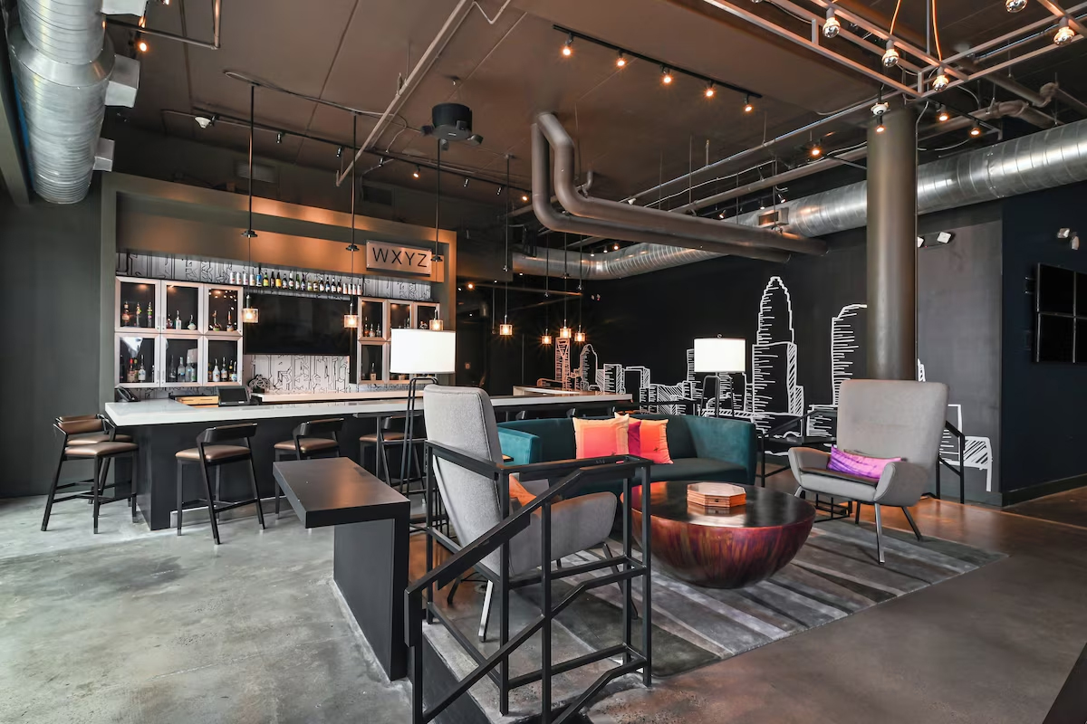Lobby inside ALoft Hotel in Charlotte, NC featuring industrial loft-inspired decor and polished concrete floors.