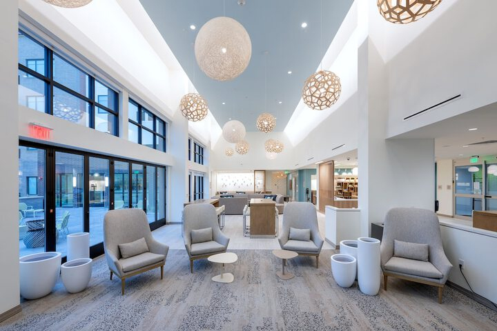 Round white and gold lights hung from ceiling of hotel lobby.