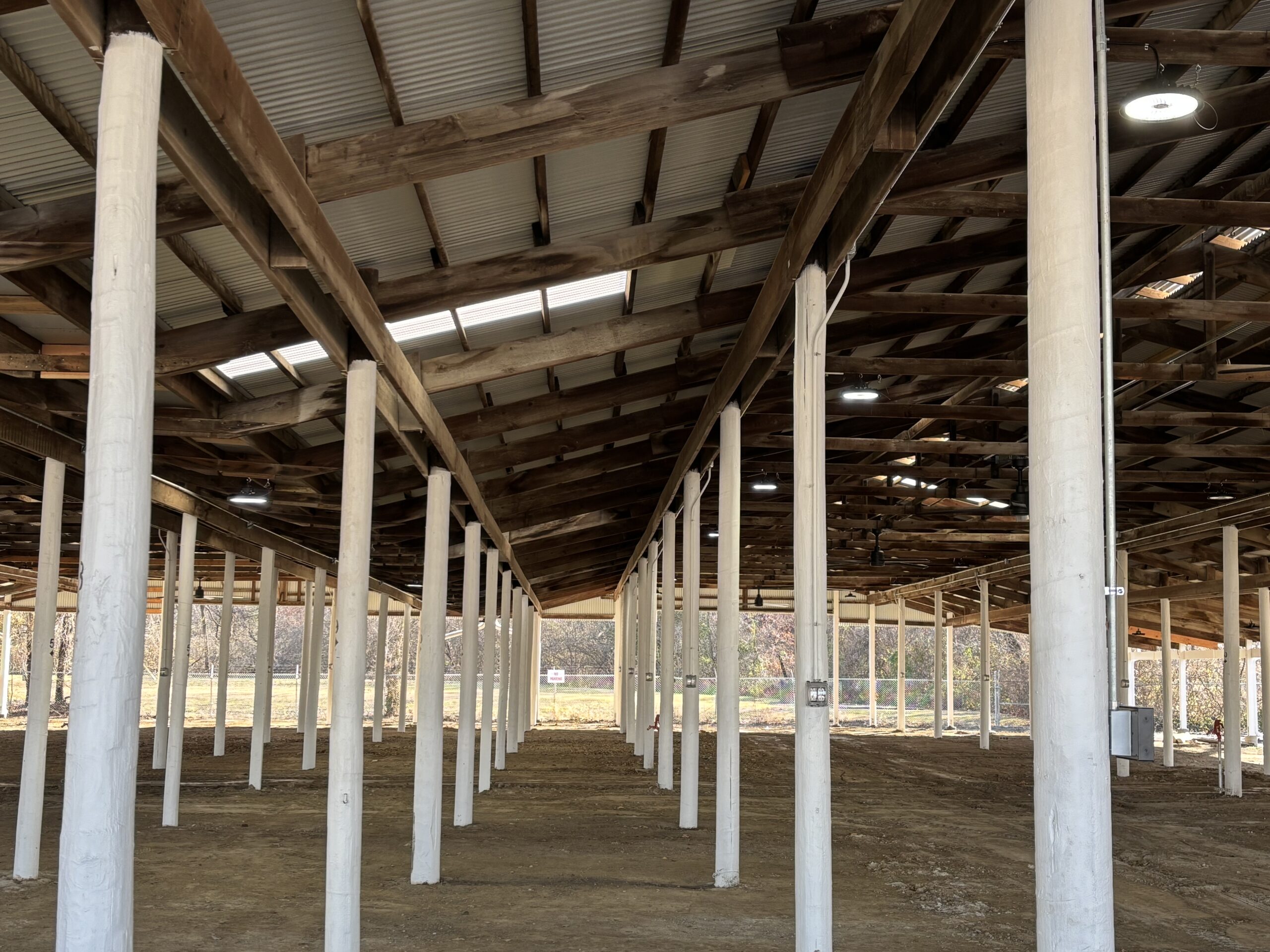 Open-air livestock shed at Belle-Clair Fairgrounds with new interior lighting and ceiling fans